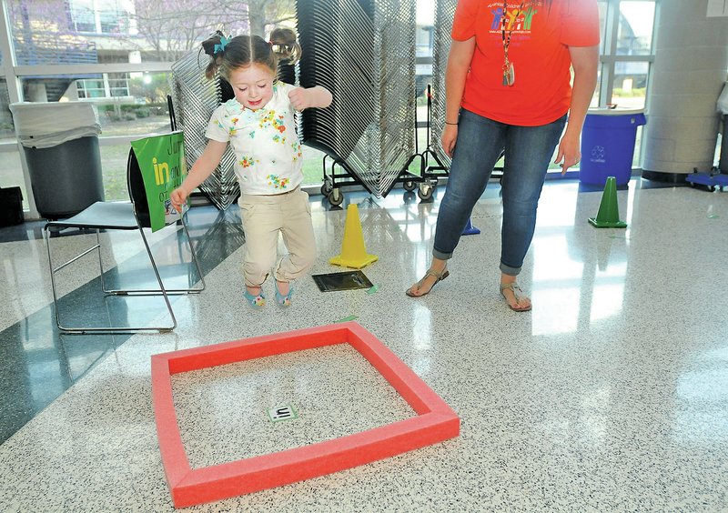 STAFF PHOTO SAMANTHA BAKER &#8226; @NWASAMANTHA Jalena Howard, right, watches as Emma Grace Garner, 3, jumps into a foam square during the Pre-K Literacy Fair. during the Pre-K Literacy Fair.