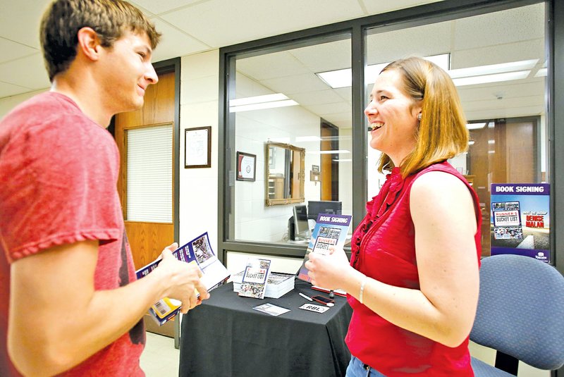  Staff Photo DAVID GOTTSCHALK James Newton, a civil engineering graduate student at the University of Arkansas in Fayetteville, left, speaks Friday with Denise Malan author of &#8220;The Runner&#8217;s Bucket List: 200 Races to Run Before You Die&#8221; in Kimpel Hall on the campus of the University of Arkansas in Fayetteville. Malan, a graduate of the University of Arkansas, was on the campus to sign her new book which tells of some of the world&#8217;s unique running adventures and races.
