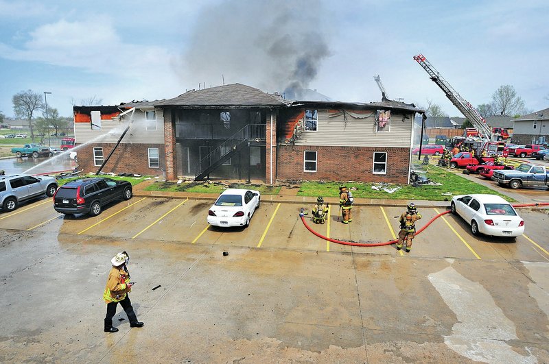 STAFF PHOTO Spencer Tirey Centerton firefighters with the help of fire departments from Bentonville, Rogers and Decatur work Saturday to extinguish an apartment fire in Centerton. &#8220;We lost everything,&#8221; Derrick Lake said. &#8220;I have no idea what to do.&#8221;