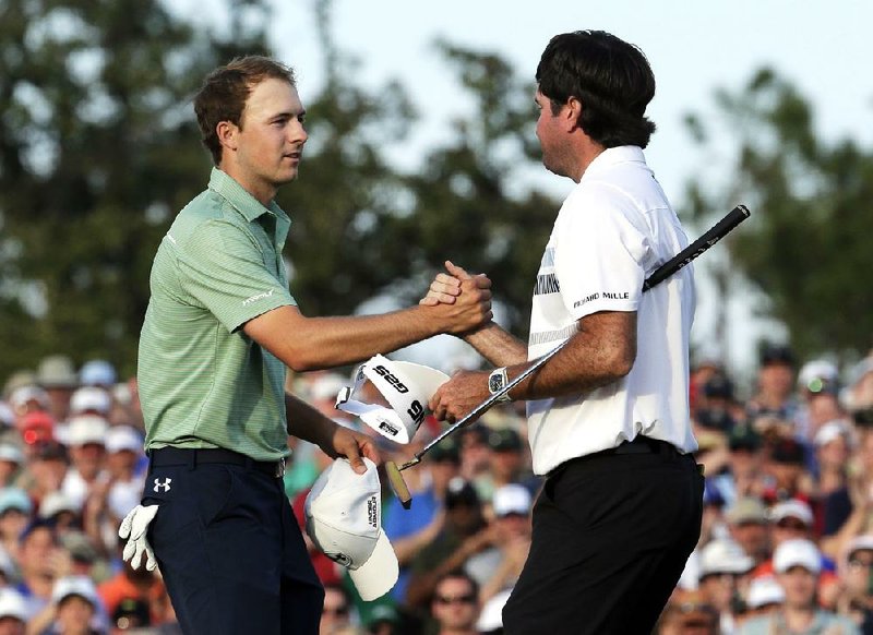 Bubba Watson, right, shakes hands with Jordan Spieth after winning the Masters golf tournament Sunday, April 13, 2014, in Augusta, Ga. (AP Photo/Charlie Riedel) 