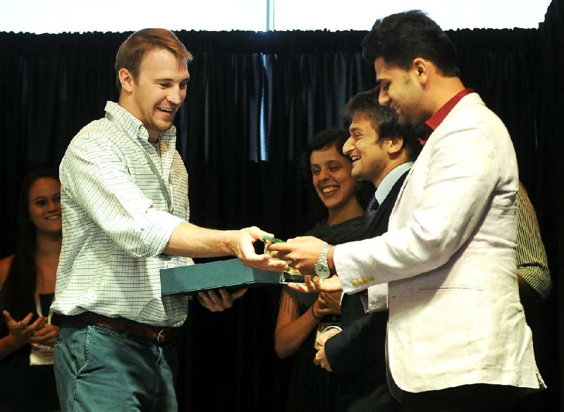 STAFF PHOTO BEN GOFF -- 09/05/13 -- ARK Challenge Associate Scott Andrews, left, presents trophies to Info Assembly co-founder Karan Singh during The Ark Challenge Demo Day event at the Crystal Bridges Museum of American Art in Bentonville on Thursday September 5, 2013. Info Assembly was one of three startup companies selected by a panel to receive seed money to advance their products. 