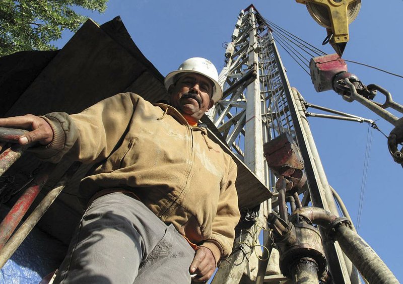 Jorge Vargas, a foreman for Maggiora Brothers Drilling Inc., poses for a photograph while drilling an 800-foot-deep water well at an almond farm in Chowchilla, Calif., on Friday, April 4, 2014. In Californias drought, well drillers are experiencing a boom in business because farmers are relying more on ground water to irrigate their crops. (AP Photo/Scott Smith)                               