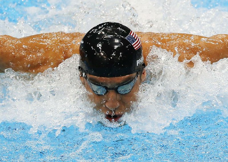 FILE - In this Aug. 4, 2012, file photo, United States' Michael Phelps swims in the men's 4 X 100-meter medley relay at the Aquatics Centre in the Olympic Park during the 2012 Summer Olympics in London. Phelps is coming out of retirement, the first step toward possibly swimming at the 2016 Rio Olympics. Bob Bowman, the swimmer's longtime coach, told The Associated Press on Monday, April 14, 2014, that Phelps is entered in three events — the 50- and 100-meter freestyles and the 100 butterfly at his first meet since the 2012 London Games at a meet in Mesa, Ariz., on April 24-26. (AP Photo/Julio Cortez, File)