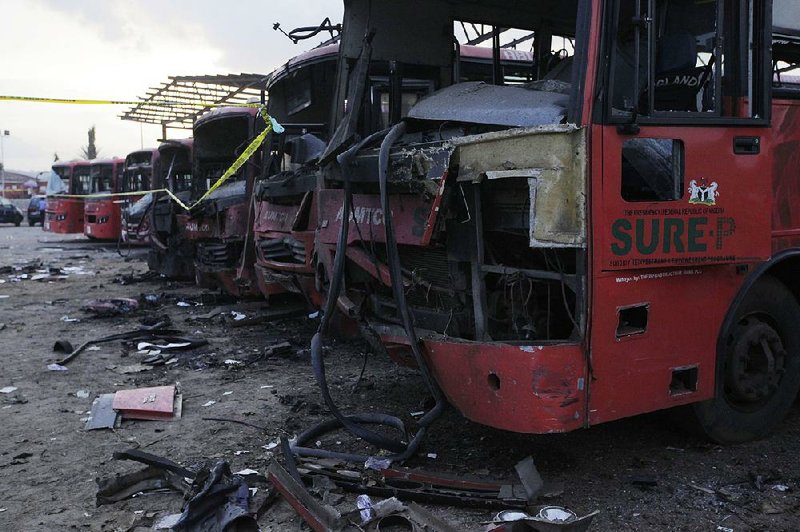 Damaged buses are seen at the scene of an explosion at a bus park in Abuja, Nigeria, Monday, April. 14, 2014. Suspected Islamic militants struck at the heart of Nigeria with a massive rush-hour explosion at a bus station Monday that killed 71, with the toll expected to rise in the deadliest attack yet on the nation’s capital. (AP Photo/ Sunday Alamba)