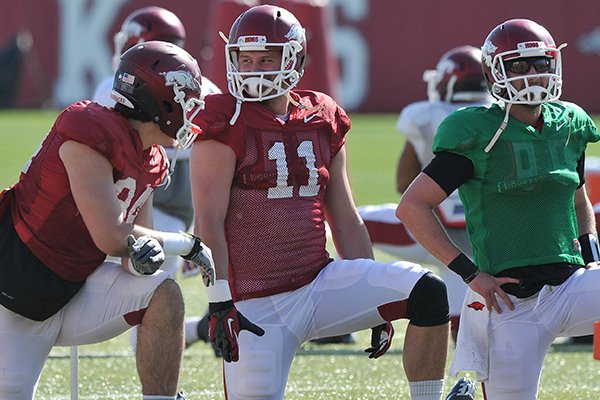 Arkansas tight end A.J. Derby (center) stretches with teammates during the Razorbacks practice Thursday afternoon in Fayetteville.