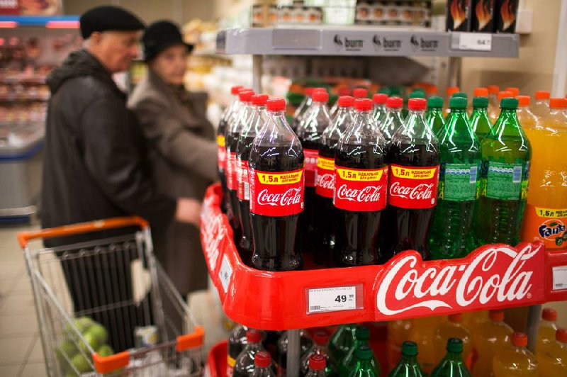 Bottles of Coca-Cola products sit on a display in a Dixy supermarket in Moscow last week. The company said Tuesday that the amount of soda it sold globally in the first quarter fell for fi rst time in 15 years. 