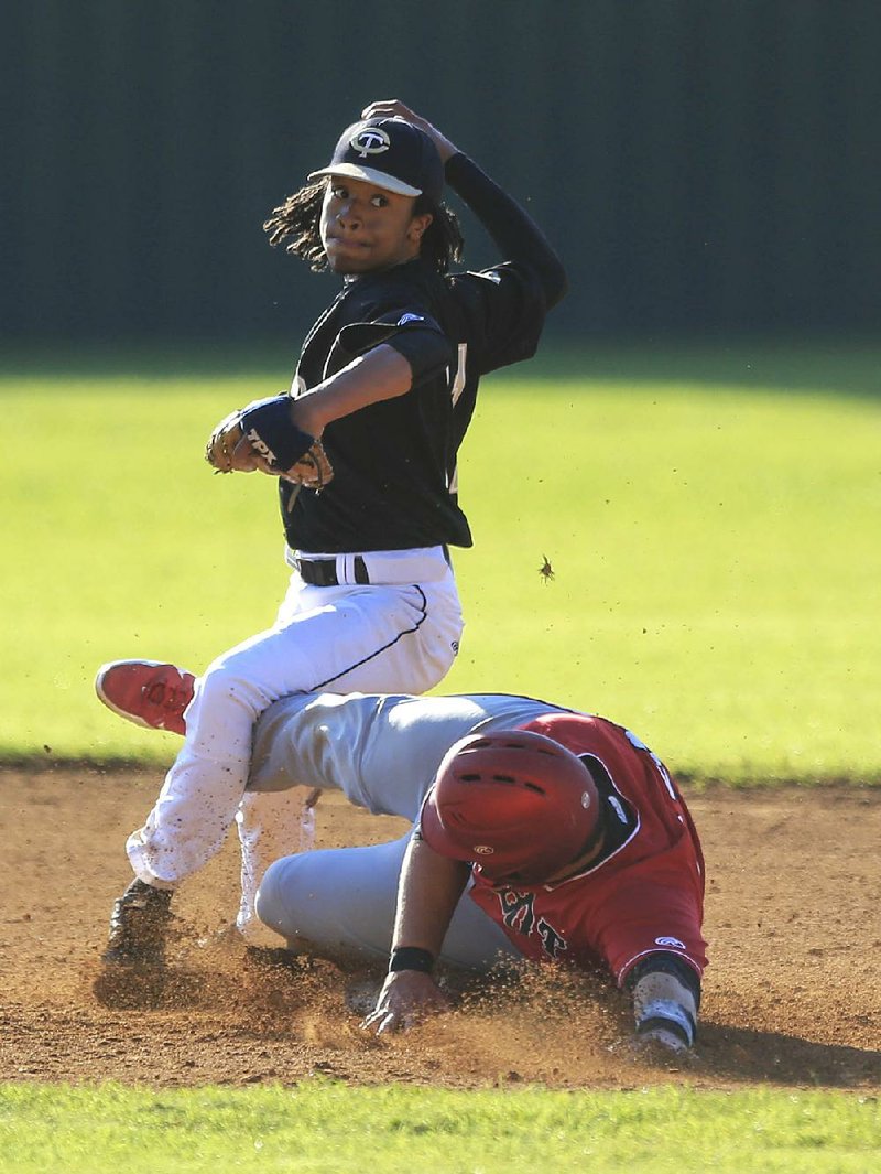 Little Rock Central second baseman Kelton Cole (top) throws the ball to first base as he attempts to turn a double play after forcing out Cabot’s Tristan Bulice during the Tigers’ 4-1 victory in the first game of Tuesday’s doubleheader at Buddy Coleman Field in Little Rock. 
