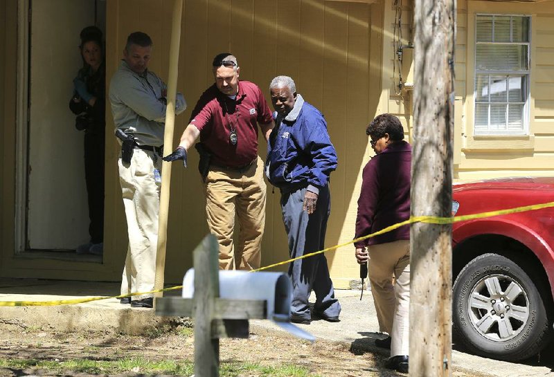 Little Rock police investigate the crime scene Tuesday at a house in the 4100 block of Tatum Street where a woman found the body of her co-worker in the house and called the police about 11 a.m. Police are treating the death as a homicide. 