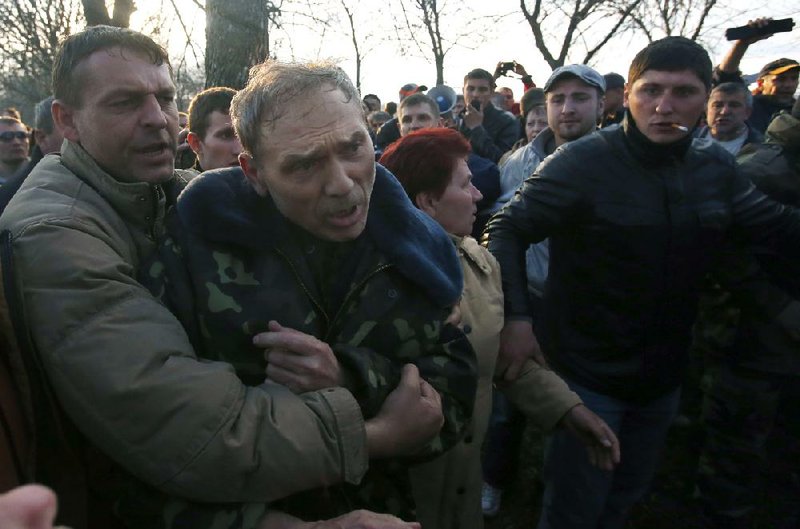 Demonstrators accost Ukrainian Gen. Vasyl Krutov outside the Kramatorsk Airport on Tuesday as he tried to dispel rumors that his troops, which had seized the airport and reportedly repelled attackers, planned to carry out operations against the city of Kramatorsk. 