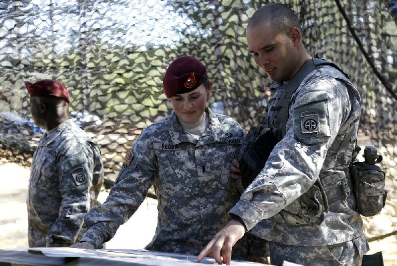 First Lt. Kelly Requa speaks with Spc. Michael Cantrell of Bravo Battery, 321st Field Artillery at a fire-direction center during certification in February at Fort Bragg, N.C. Requa is breaking new ground at Fort Bragg as one of a small number of female lieutenants named to lead cannon platoons at the North Carolina base. 