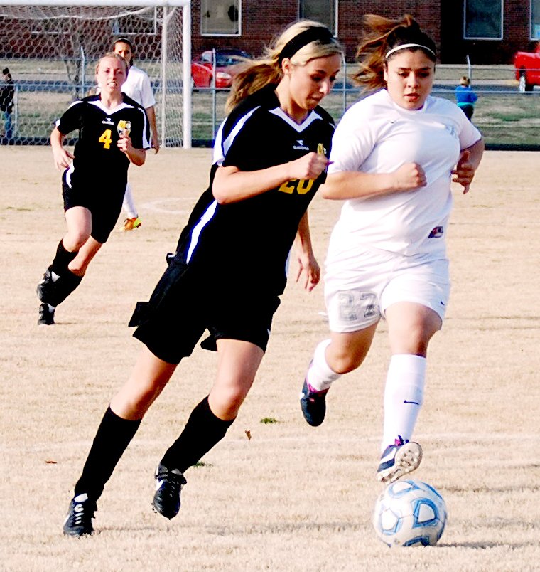 BEN MADRID ENTERPRISE-LEADER Prairie Grove&#8217;s Celeste Mesenbrink battles a Siloam Springs player for control of the ball while teammate Aryanna Mitchell moves in to support her. The Lady Tigers lost to the Panthers 3-1 on April 1.