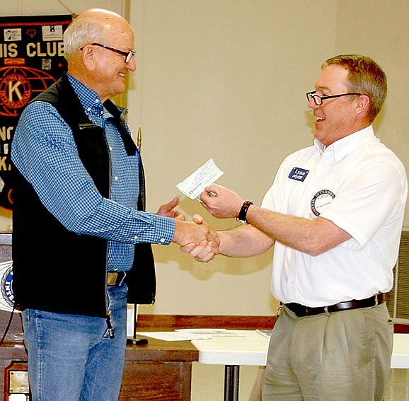 Photo by PAT HARRIS ENTERPRISE-LEADER Neil Helm, left, accepted a $305 check last Wednesday for GRACE Place from Lynn Thomas, president of the Lincoln Kiwanis Club. GRACE Place is a non-profit organization that helps with food and clothing assistance for those in need.