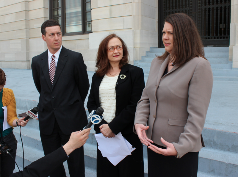 ACLU of Arkansas legal director Holly Dickson, right, speaks on the steps of the Pulaski County Courthouse Wednesday about a lawsuit challenging the state's voter ID law while the organization's executive director, Rita Sklar, and cooperating attorney Jeff Priebe look on.