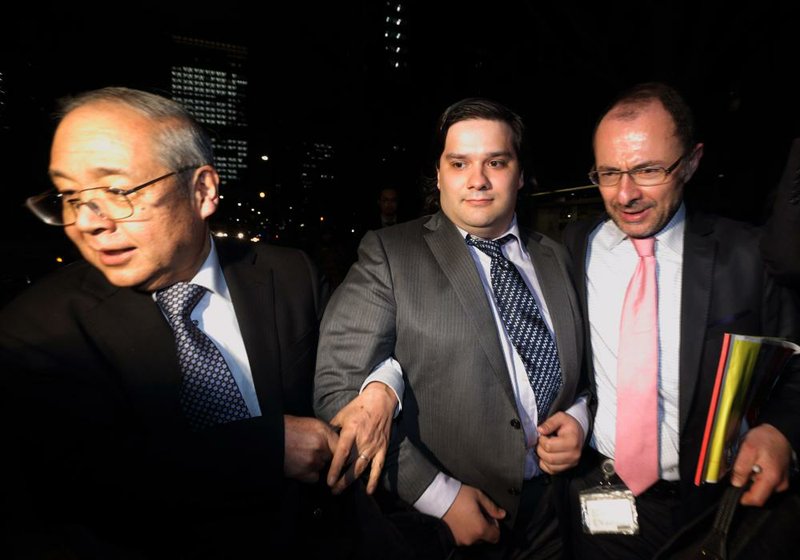 Mark Karpeles, (center) chief executive officer of bitcoin exchange Mt. Gox, leaves Tokyo District Court in February after filing for the company’s bankruptcy, which was denied Wednesday. 