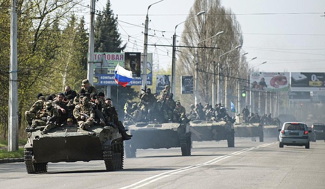 Pro-Russian insurgents drive Ukrainian armored vehicles through the eastern Ukrainian town of Kramatorsk on Wednesday after commandeering them from troops who had entered the town earlier. As Ukraine’s hopes of re-establishing control of the area dampened, NATO announced a strengthening of its military presence along some members’ borders with Russia.