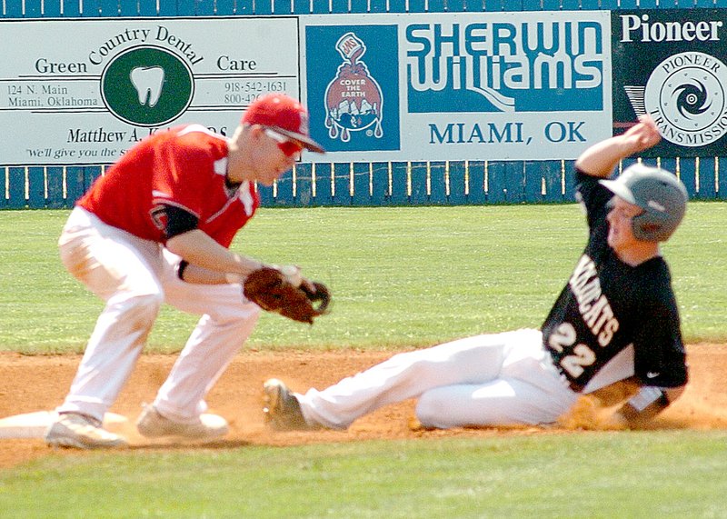 Neosho&#8217;s Colton Marion slides into second base just ahead of a tag by McDonald County&#8217;s Evan Acuff during the Wildcats&#8217; 7-5 win Friday in the Mickey Mantle Wood Bat Tournament in Commerce, Okla.