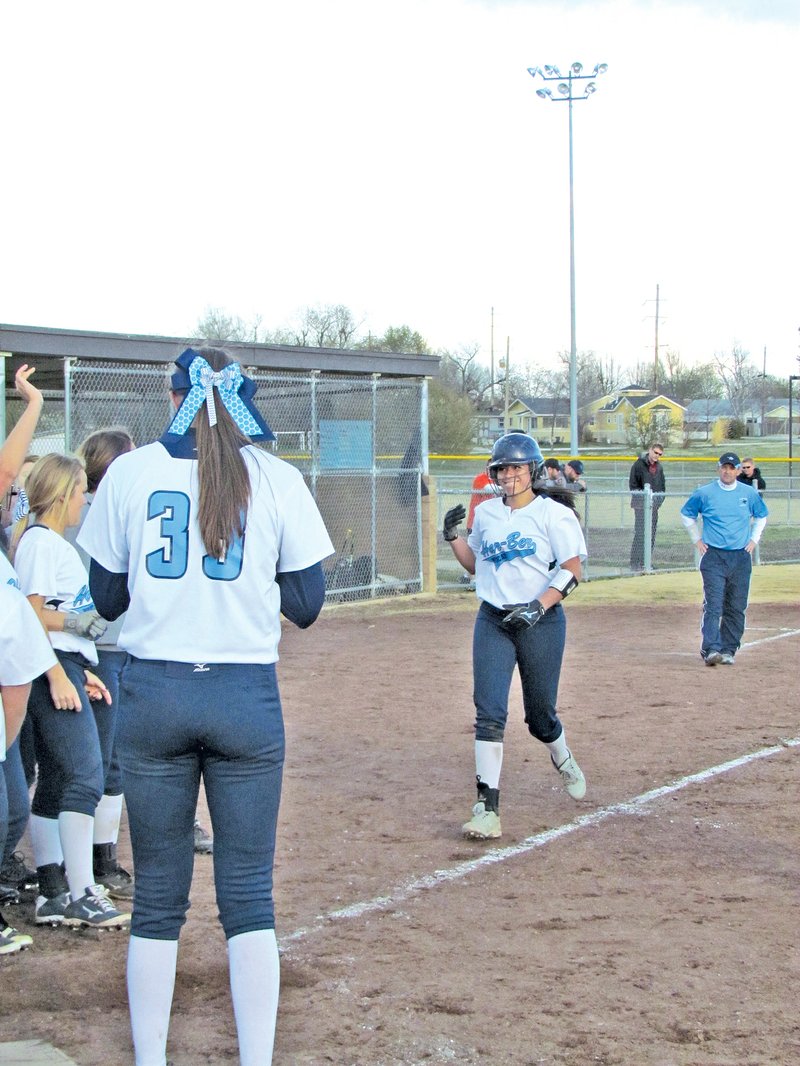 STAFF PHOTO RICK FIRES Kylie Buttram, right, is greeted by Springdale Har-Ber players after she hit her first career home run during a game against Rogers.