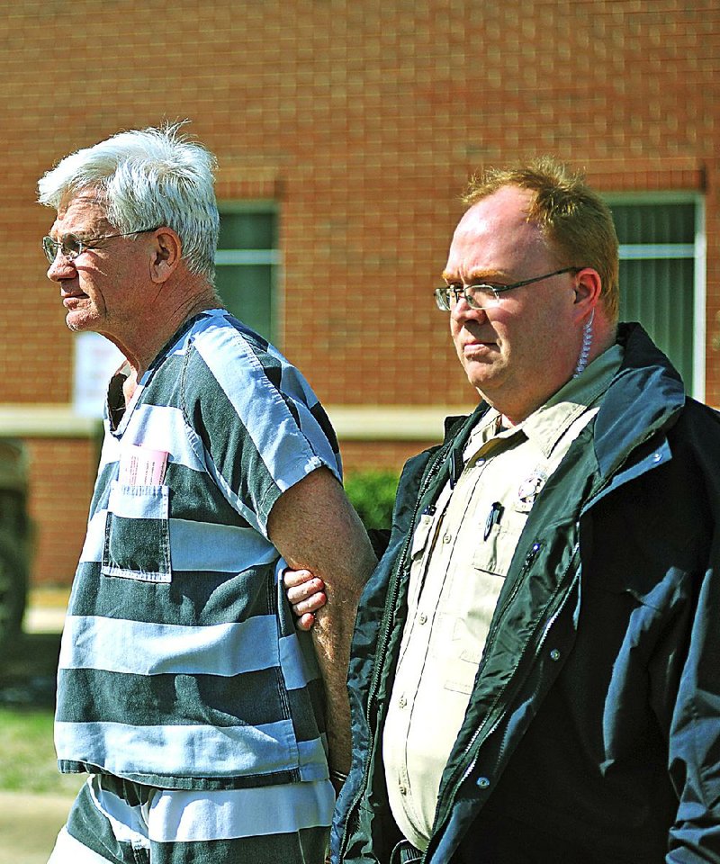 Dr. Paul Becton, left, an obstetrician-gynocologist of Paragould is escorted by a Greene County sheriff's deputy on Thursday, April 17, 2014, after a probable cause hearing at the Greene County Courthouse in Paragould. Becton is charged with taking photographs of a nude female patient and was ordered held in lieu of $500,000 bond.