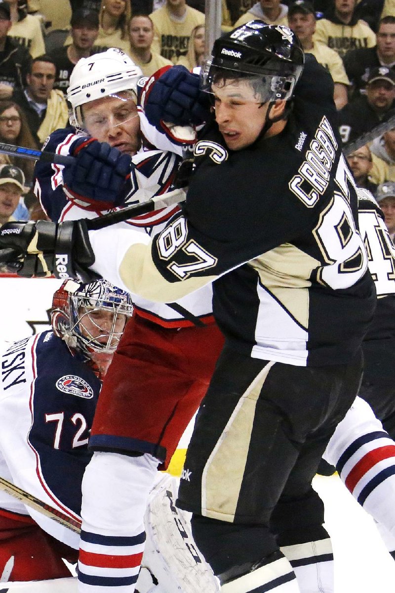 Columbus Blue Jackets' Jack Johnson (7) tries to clear Pittsburgh Penguins' Sidney Crosby (87) from in front of Blue Jackets goalie Sergei Bobrovsky (72) in the second period of a first-round NHL playoff hockey game in Pittsburgh Wednesday, April 16, 2014.(AP Photo/Gene J. Puskar)