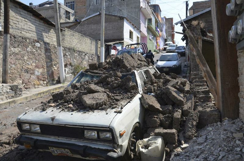 Friday morning’s earthquake shook loose an adobe wall that collapsed, crushing a car in Chilpancingo, Mexico. 