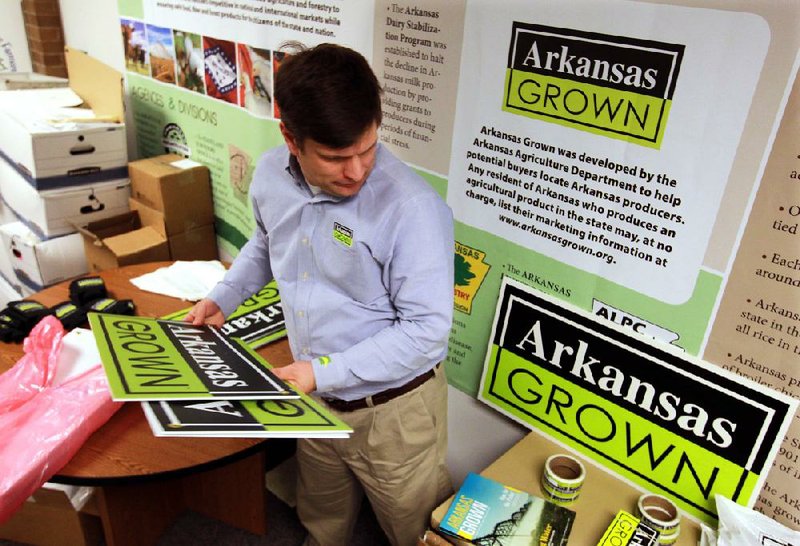 Zach Taylor, marketing director for the the Arkansas Agriculture Department, prepares materials for some of the businesses and people registered in the Arkansas Grown program, which connects Arkansas produce farmers and ranchers with buyers, including farmers markets, schools, restaurants and grocery chains. 