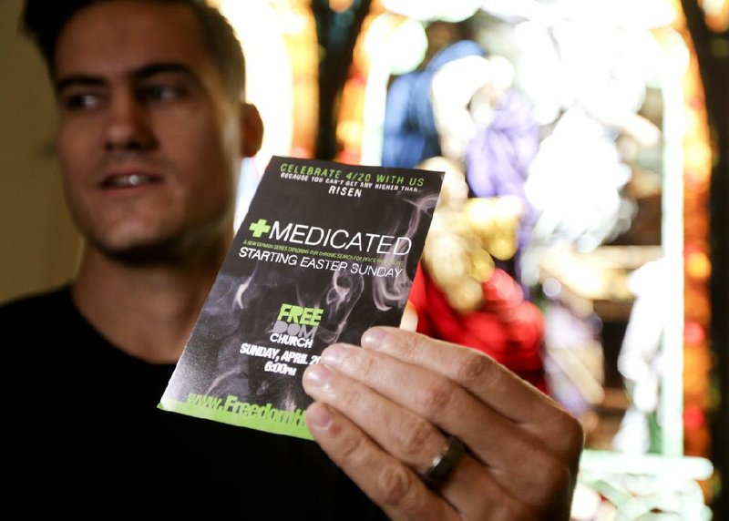 Pastor Justice Coleman, founder of Freedom Church poses for a picture with a flyer from his coming service Thursday, April 17, 2014 in Highland Park, Calif. Coleman  is using medical marijuana imagery and catchy word play to attract new worshippers to an Easter sermon series called "Medicated," about seeking fulfillment through God, not drugs. (AP Photo/Chris Carlson)