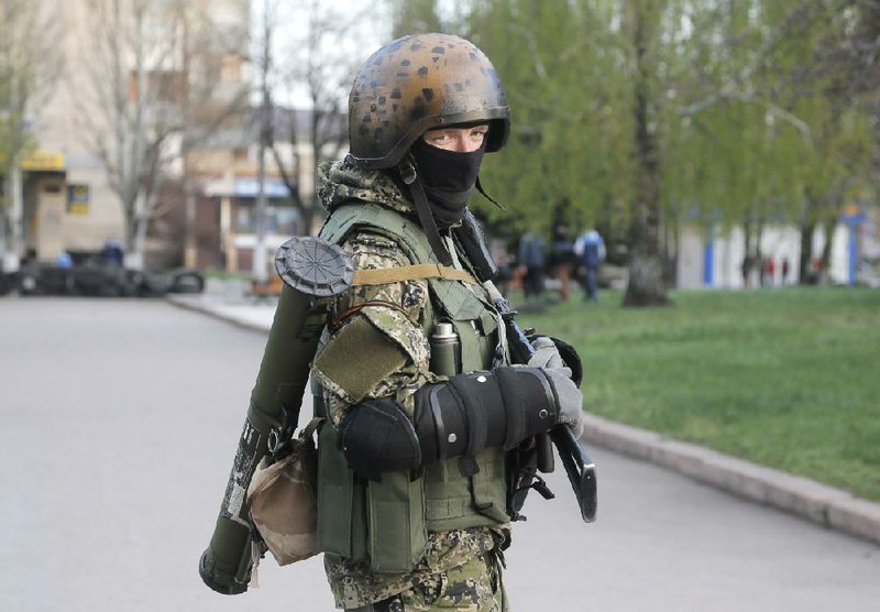 A pro-Russian gunman patrol a streets in downtown Slovyansk, eastern Ukraine, Friday, April 18, 2014. Dashing hopes of progress raised by a diplomatic deal in Geneva, pro-Russian insurgents who have occupied government buildings in more than 10 Ukrainian cities said Friday they will not leave them until the country's interim government resigns. (AP Photo/Efrem Lukatsky)