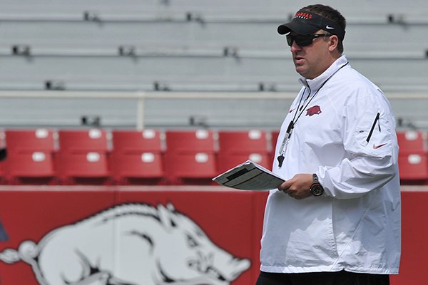 Arkansas coach Bret Bielema works with his team before the start of a football scrimmage Saturday, April 12, 2014 at Razorback Stadium in Fayetteville.