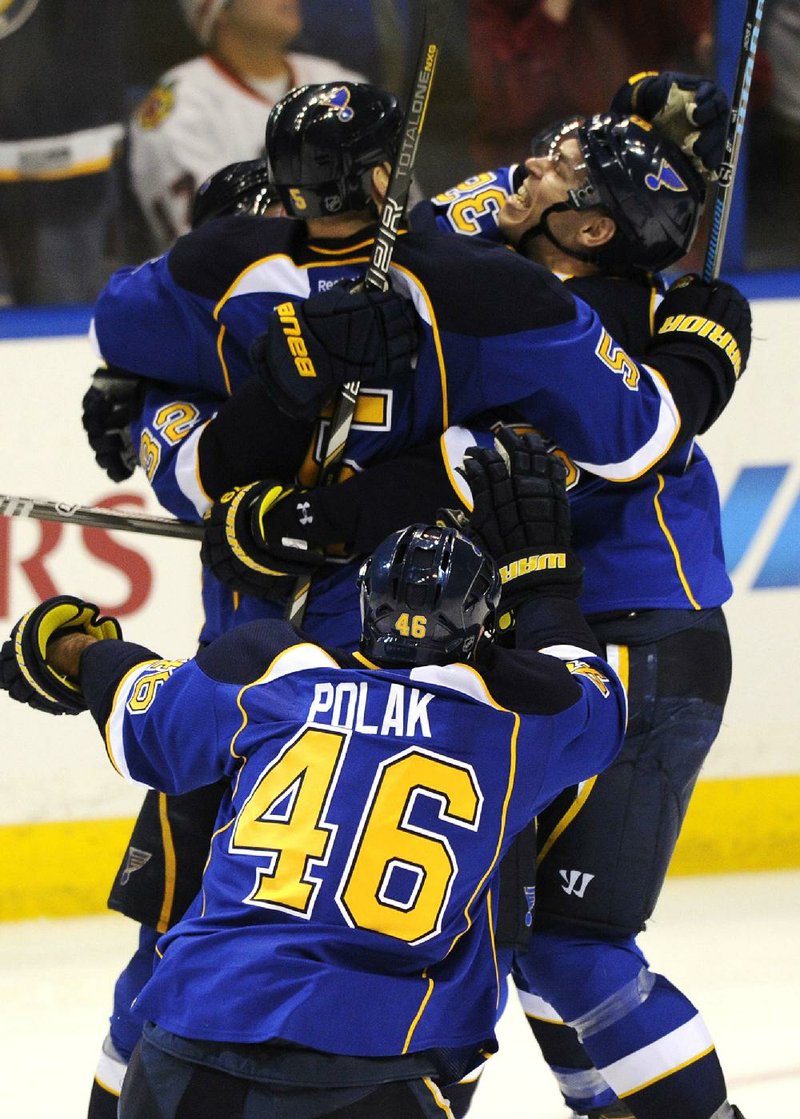 St. Louis Blues defenseman Barret Jackman (5) is congratulated by teammates Adam Cracknell (right) and Roman Polak (46) after scoring the game-winning goal against the Chicago Blackhawks in overtime of their first-round NHL playoff game Saturday in St. Louis. The Blues won 4-3 and took a 2-0 series lead. 