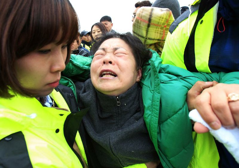 A relative of a missing ferry passenger is overcome as she waits with others for news of rescue efforts Saturday at the port in Jindo, South Korea. 