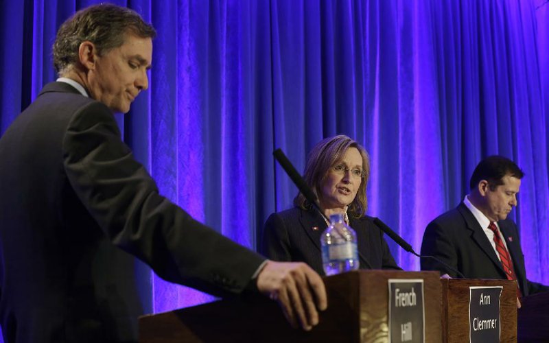Ann Clemmer (center) asks French Hill (left) a question as Col. Conrad Reynolds (right) listens during a debate between the Republican congressional hopefuls Saturday in Little Rock. 
