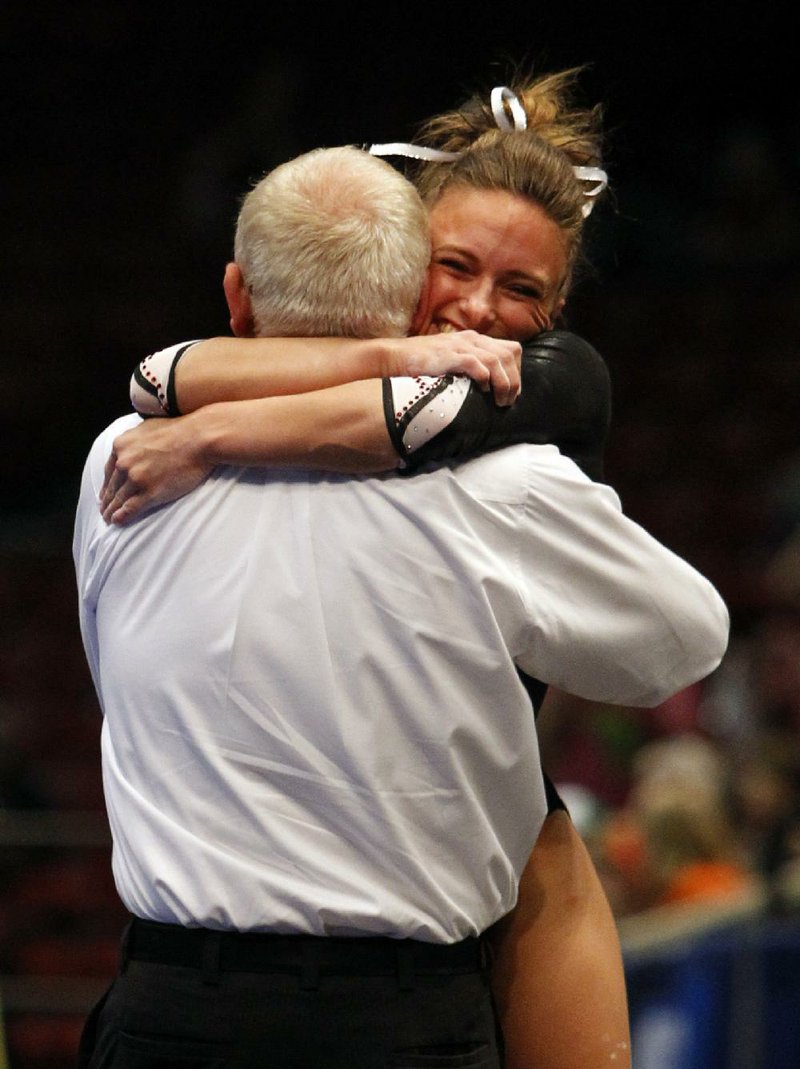 Arkansas' Katherine Grable, right, celebrates with coach Mark Cook after competing on the vault during the individual competition at the NCAA college women's gymnastics championships on Sunday, April 20, 2014, in Birmingham, Ala. (AP Photo/Butch Dill)