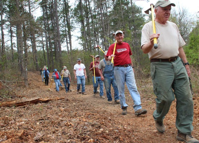 Arkansas Democrat-Gazette/CELIA STOREY
Jerry Shields leads the finishing crew of LOViT Traildogs out of the woods for the final time April 11 at the easternmost section of the  Lake Ouachita Vista Trail (LOViT) on the southern shore of Lake Ouachita. Following Shields are Al Gathright, Robert Cavanaugh, Dan Watson, Jay Marsh, MIke Curran (hidden), Derwood Brett, James Baggenstoss, Bruce Alt (in orange), John Nichols and others.