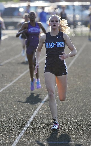 STAFF PHOTO MICHAEL WOODS Amanda Dillon crosses the finish line after setting a meet record while winning the 400-meter run at the Fayetteville Bulldogs Relays. Dillon won in a time of 55.55 seconds.