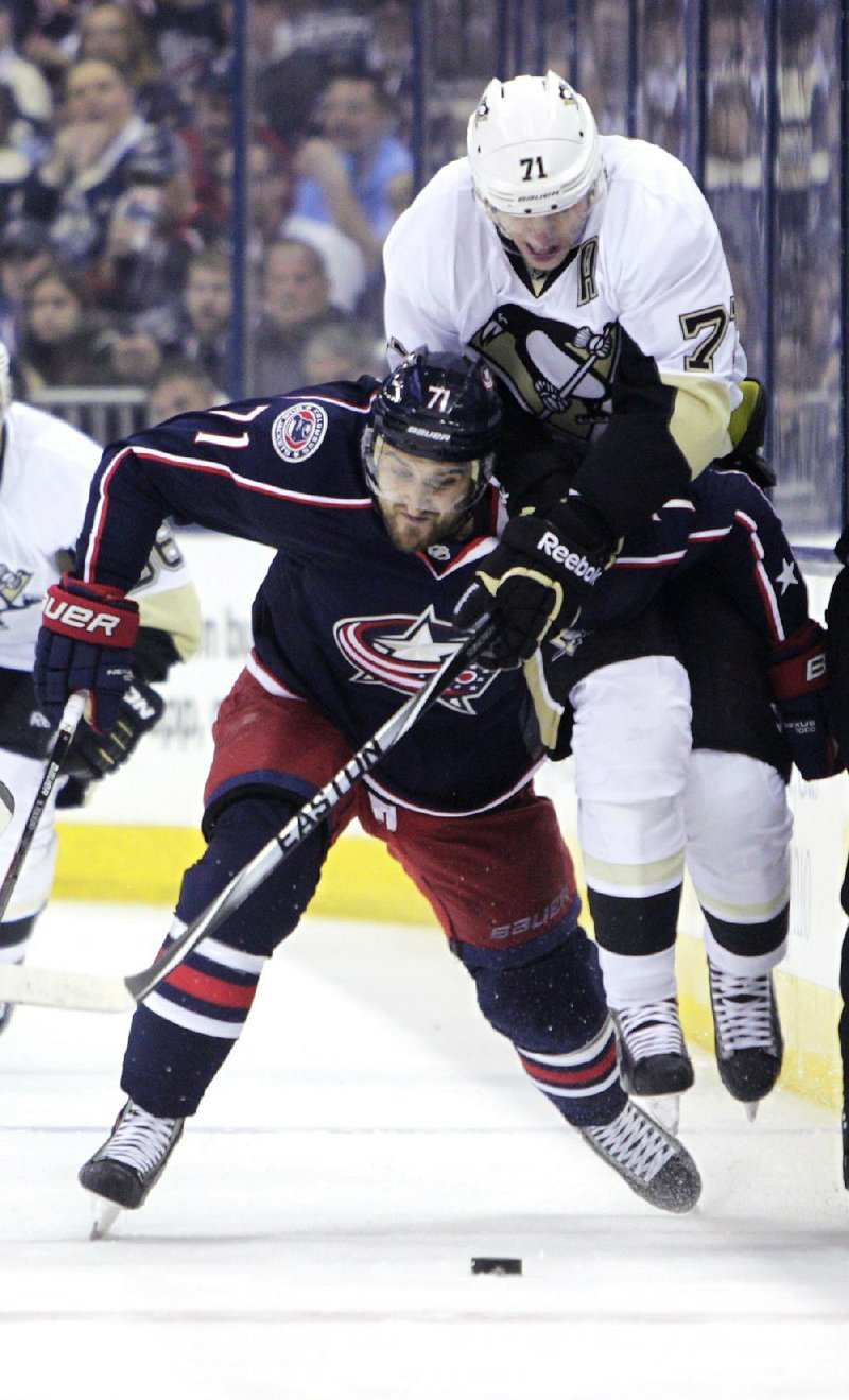 Pittsburgh Penguins' Evgeni Malkin, right, of Russia, and Columbus Blue Jackets' Nick Foligno chase a loose puck during the first period of a first-round NHL playoff hockey game Monday, April 21, 2014, in Columbus, Ohio. (AP Photo/Jay LaPrete)
