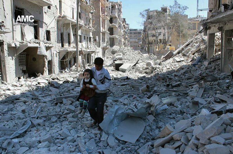 This photo provided by the anti-government activist group Aleppo Media Center (AMC), which has been authenticated based on its contents and other AP reporting, shows a Syrian man holding a girl as he stands on the rubble of houses that were destroyed by Syrian government forces air strikes in Aleppo, Syria, Monday, April 21, 2014. Syria will hold presidential elections on June 3, the country's parliament speaker announced Monday, a vote President Bashar Assad is likely to win, as the country enters its fourth year of war. (AP Photo/Aleppo Media Center AMC) 