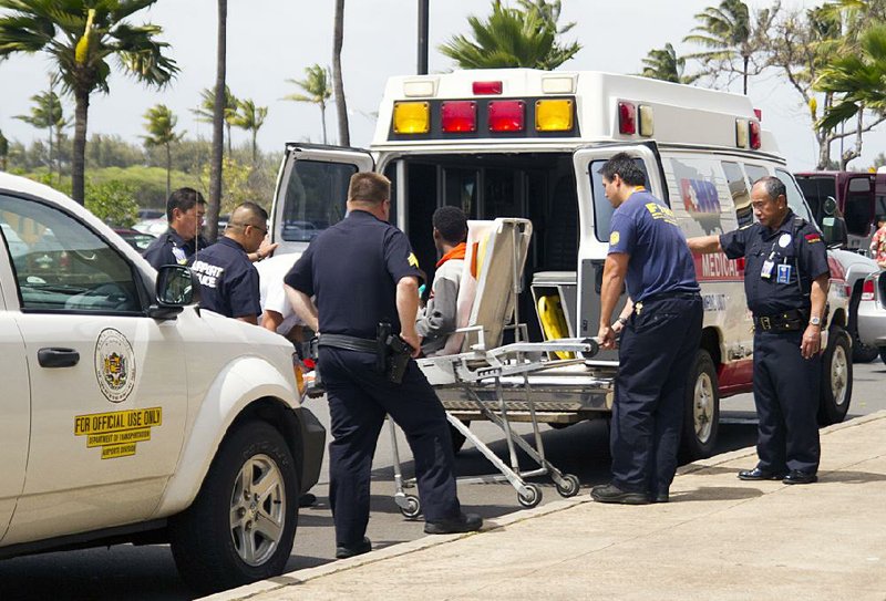 A 16-year-old boy, seen sitting on a stretcher center, who stowed away in the wheel well of a flight from San Jose, Calif., to Maui is loaded into an ambulance at Kahului Airport in Kahului, Maui, Hawaii Sunday afternoon, April 20, 2014. The boy survived the trip halfway across the Pacific Ocean unharmed despite frigid temperatures at 38,000 feet and a lack of oxygen, FBI and airline officials said. FBI spokesman Tom Simon in Honolulu told The Associated Press on Sunday night that the boy was questioned by the FBI after being discovered on the tarmac at the Maui airport with no identification. "Kid's lucky to be alive," Simon said. (AP Photo/The Maui News, Chris Sugidono)