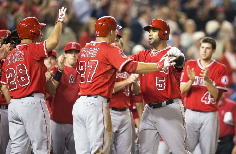 Los Angeles Angels first baseman Albert Pujols (5) is greeted by teammate Mike Trout (27) after Pujols hit his second home run of the game, the 500th of his career, against Washington on Tuesday. 