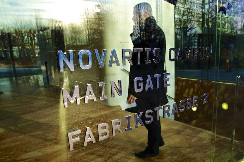 A man stands inside Novartis AG’s headquarters in Basel, Switzerland, in January. The drug maker on Tuesday announced multibillion dollar deals with GlaxoSmithKline PLC and the Eli Lilly & Co. 