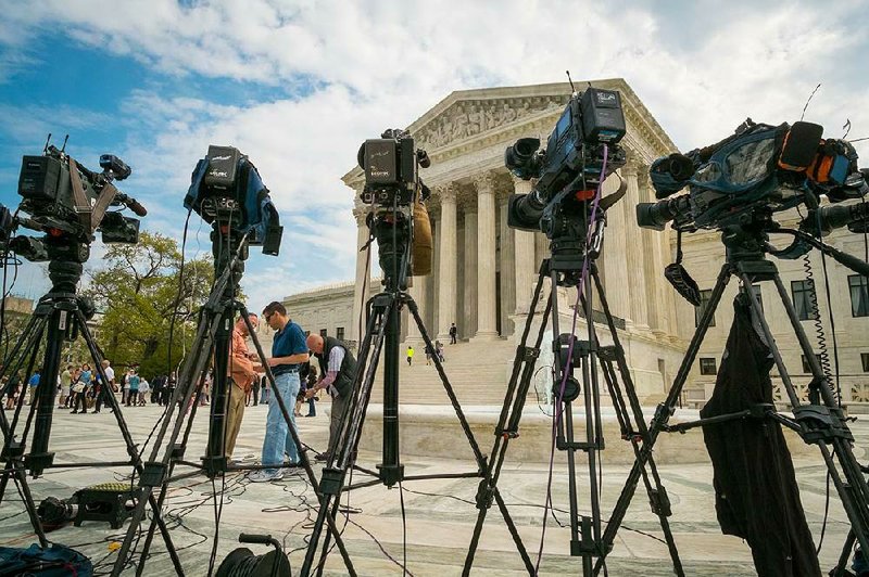 News cameras sit outside the Supreme Court building in Washington on Tuesday as the court hears arguments about a startup company seeking to bypass broadcast and cable delivery by selling television programming over the Internet. 
