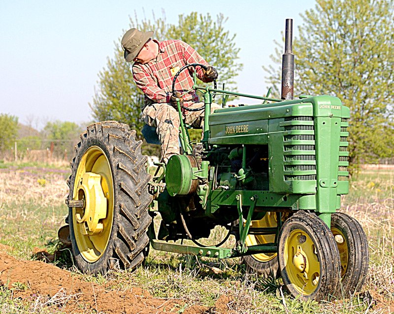 Jack Daugherty of Siloam Springs plows a field with a John Deere 1941 Model H tractor and a single-bottom plow at the Tired Iron of the Ozarks show on Friday.