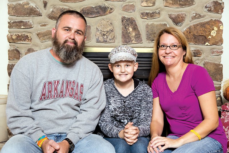 Brad and Gina Windle sit with Maddie Grace Windle, 11, the couple’s only child, at their home in Aplin. Maddie, who has been diagnosed with cancer three times, returned in March from getting a stem-cell transplant. The Grace Race 5K walk and run, named for her, will be held Saturday during Fourche River Days in downtown Perryville.