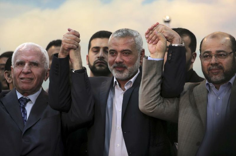 Senior Fatah official Azzam al-Ahmad (left), Gaza’s Hamas prime minister, Ismail Haniyeh, and senior Hamas leader Moussa Abu Marzouk show their support Wednesday for an agreement between Hamas and Palestine Liberation Organization at Haniyeh’s residence in the Shati refugee camp in the Gaza Strip. 