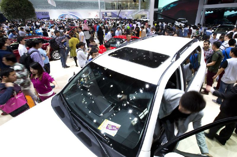 Visitors look at Toyota vehicles displayed Wednesday at the China Auto Show in Beijing. Sales of Toyota cars and trucks rose about 6 percent to 2.58 million in the January-to-March period. 