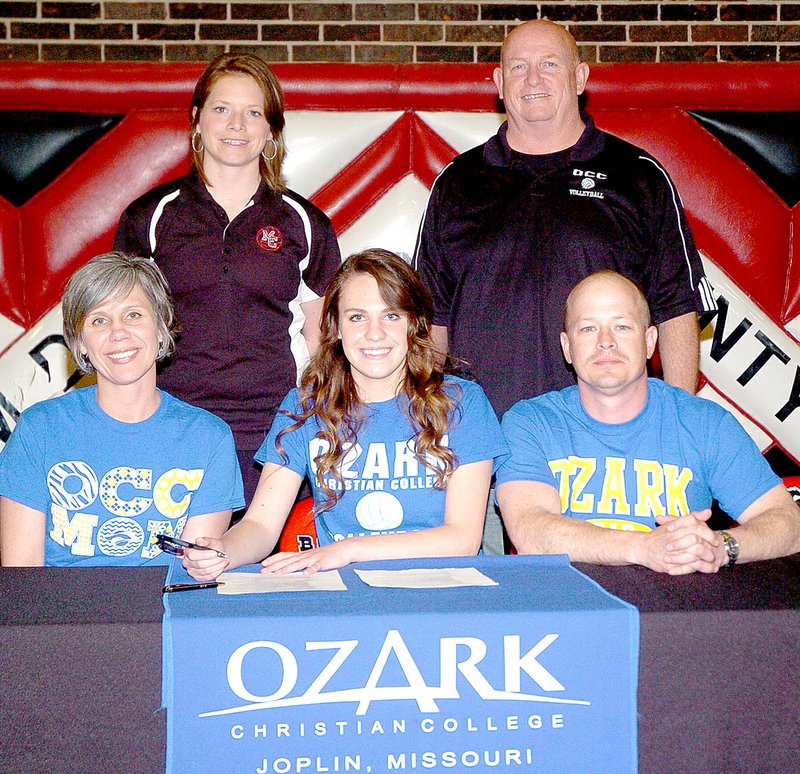 RICK PECK MCDONALD COUNTY PRESS Shobi Burris, a senior at McDonald County High School, recently signed a letter of intent to play collegiate volleyball at Ozark Christian College in Joplin. Seated from left to right: Punky Merritt (Mom), Burris and Jeremy Merritt (Dad). Back row: Kacha Kuhn, MCHS coach, and Tony Allmoslecher, OCC coach.