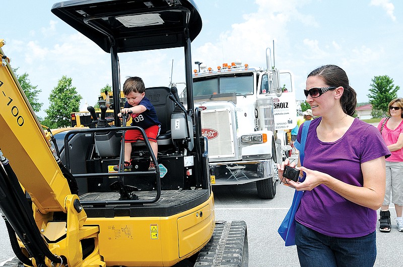 FILE PHOTO 
Carson Tanis and his mom, Alison Tanis of Rogers, sit in one of the trucks and heavy equipment on display as part of the Junior League of Northwest Arkansas’ Touch a Truck fundraiser. This year’s family-friendly event is May 3 at Pinnacle Hills Promenade in Rogers.