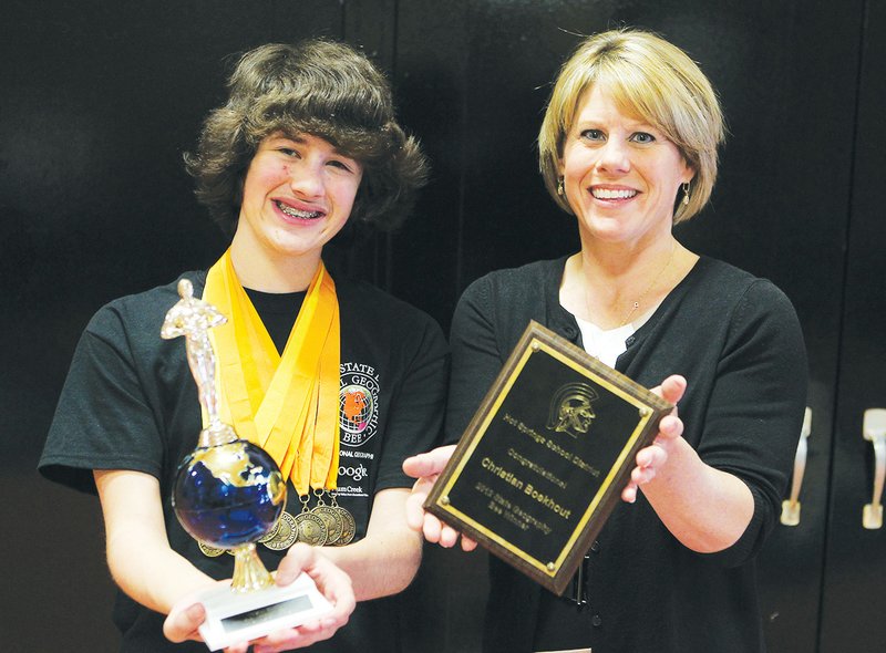 The Sentinel-Record/Richard Rasmussen FOUR-TIME WINNER: Hot Springs Middle School student Christian Boekhout, left, and Becky Rosburg, executive principal of Hot Springs Intermediate School and Park Magnet, display some of Boekhout's many trophies from geographic bees over the last seven years. Boekhout will compete for the final time in the National Geographic Bee in Washington, D.C., in May.