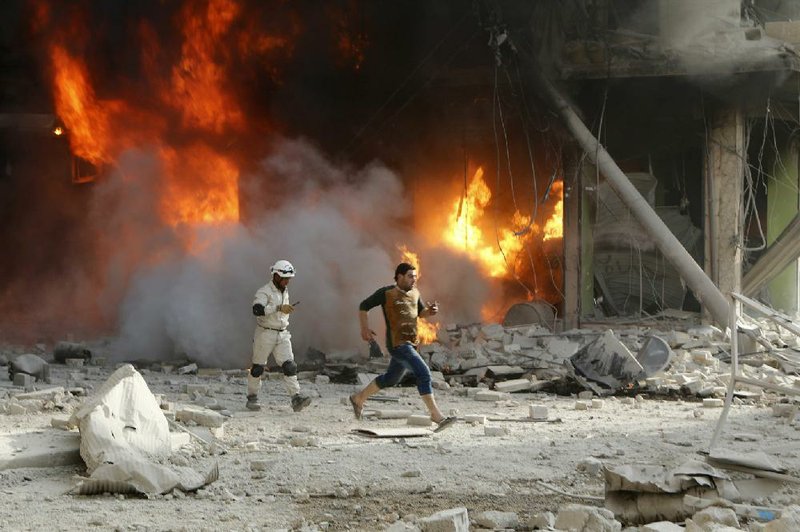 Fire flares after government airstrikes Thursday in a rebel town in Aleppo province. Activists said bombs hit a crowded vegetable market. 