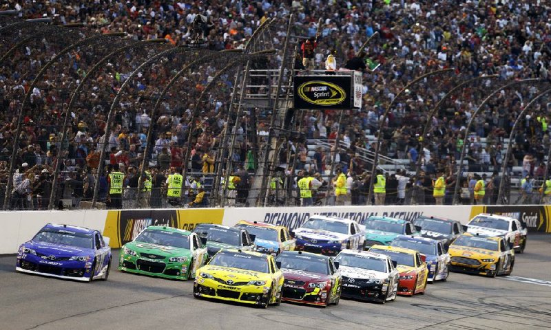 FILE - In this April 27, 2013, file photo, Matt Kenseth, front right, leads the field at the start of the NASCAR Sprint Cup auto race at Richmond International Raceway in Richmond, Va. From 2-4:30 p.m. on Saturday, April 26, fans can walk the entire track, enjoy live music, tour a NASCAR hauler and visit key spots in the track's history. Track president Dennis Bickmeier says the idea spawned from a survey the track did with ticker-holders who stopped coming. (AP Photo/Steve Helber, File)