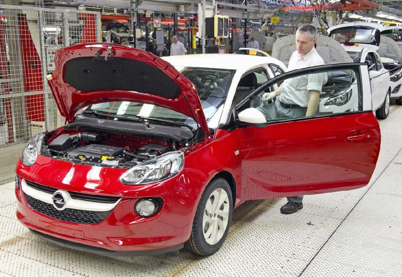 FILE - In this April 23, 2014 file photo, a worker completes an Opel Adam car at the German car company Opel Eisenach GmbH, owned by General Motors, in Eisenach, Germany. General Motors reports quarterly earnings on Thursday, April 24, 2014. (AP Photo/Jens Meyer, File)